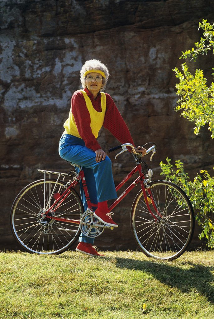 Detail of 1980s Senior Woman On Bicycle Standing Still Looking At Camera by Anonymous