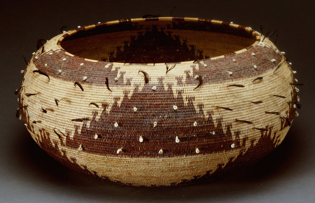 Detail of A fine and large Pomo gift basket of willow, redbud and sedge root with attached quail feathers and clam shells by Corbis