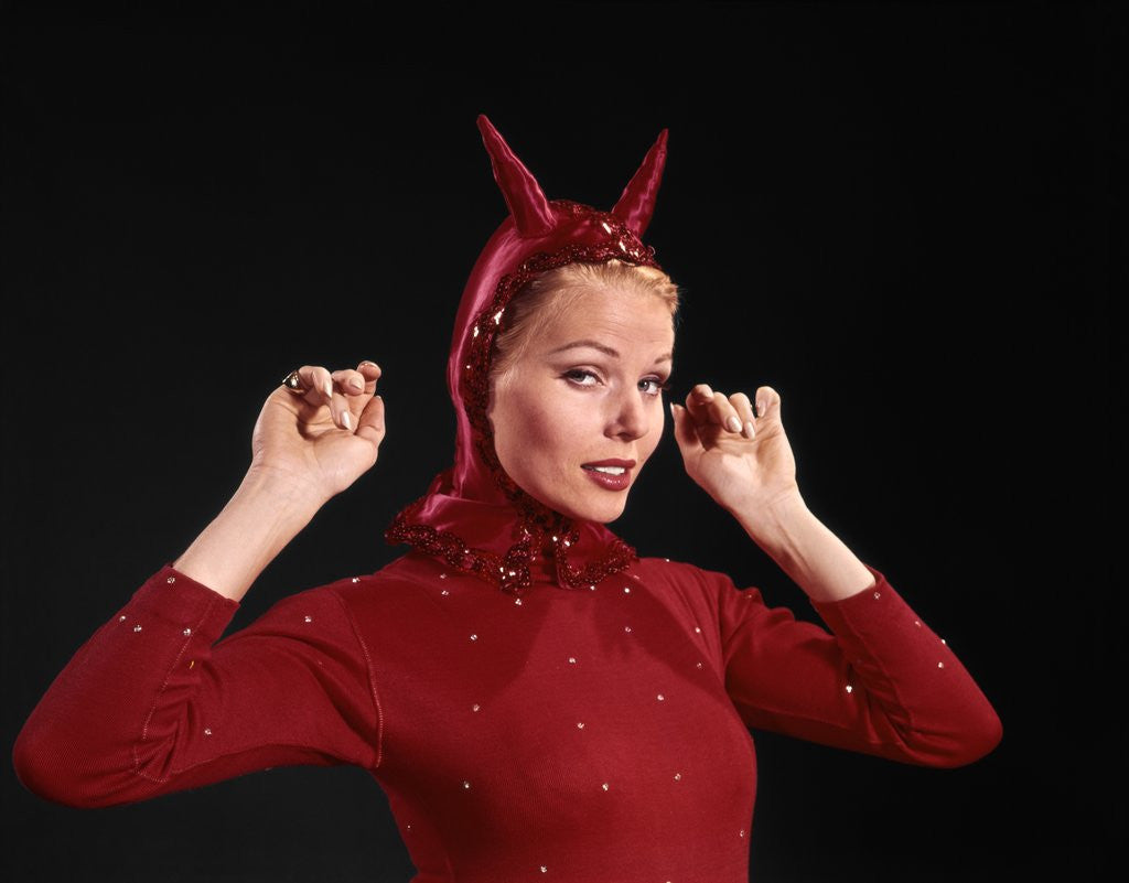 Detail of 1960s Woman Red Devil Costume With Horns Arms Up In Air Looking Seductively At Camera by Anonymous