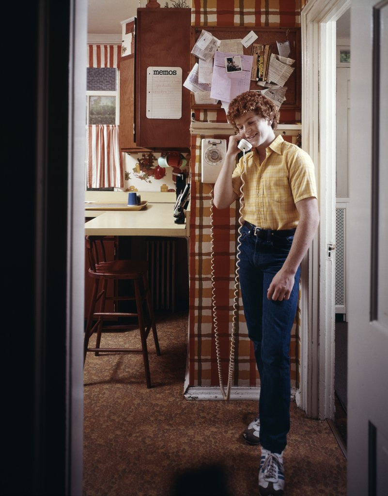 Detail of 1970s Teenage Boy Talking On Kitchen Wall Phone Telephone by Corbis