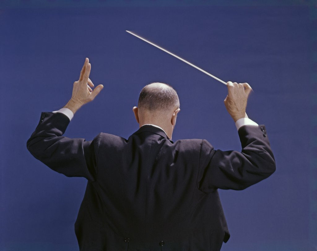 Detail of 1950s 1960s 1970s View Of Back Of Bald Man Conducting A Symphony Orchestra by Anonymous