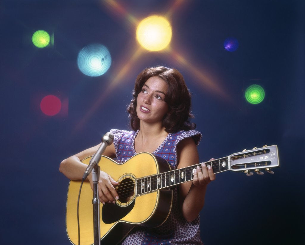 Detail of 1970s Woman Girl Performer Playing Guitar Singing Microphone Stage Lights by Corbis