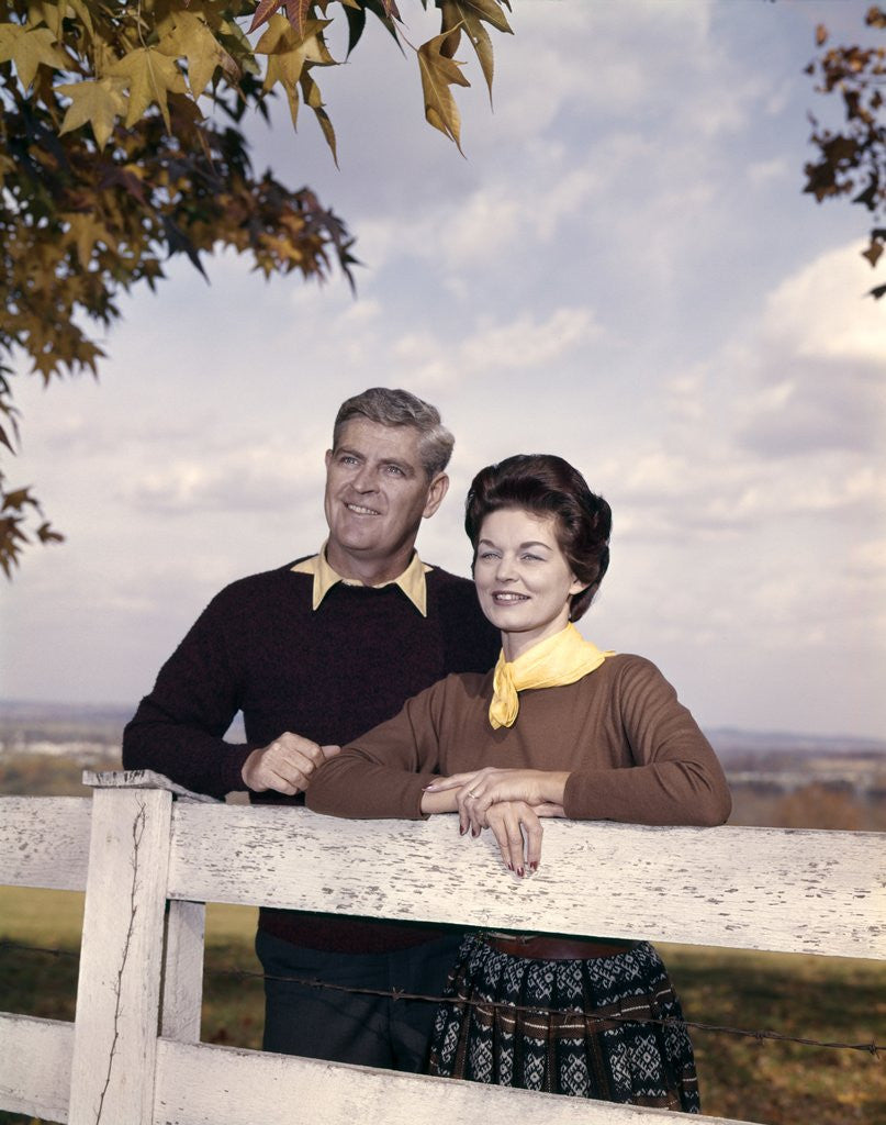 Detail of portrait Couple Husband & Wife Smiling Standing Together Behind White Board Fence Outdoor by Anonymous