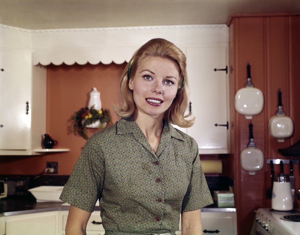 Detail of 1960s Portrait Young Blonde Woman Housewife In Kitchen Smiling Looking At Camera by Corbis