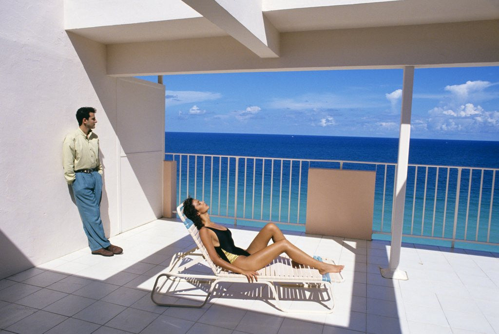 Detail of 1990s Man And Woman On Sunny Deck Balcony Overlooking The Ocean by Anonymous