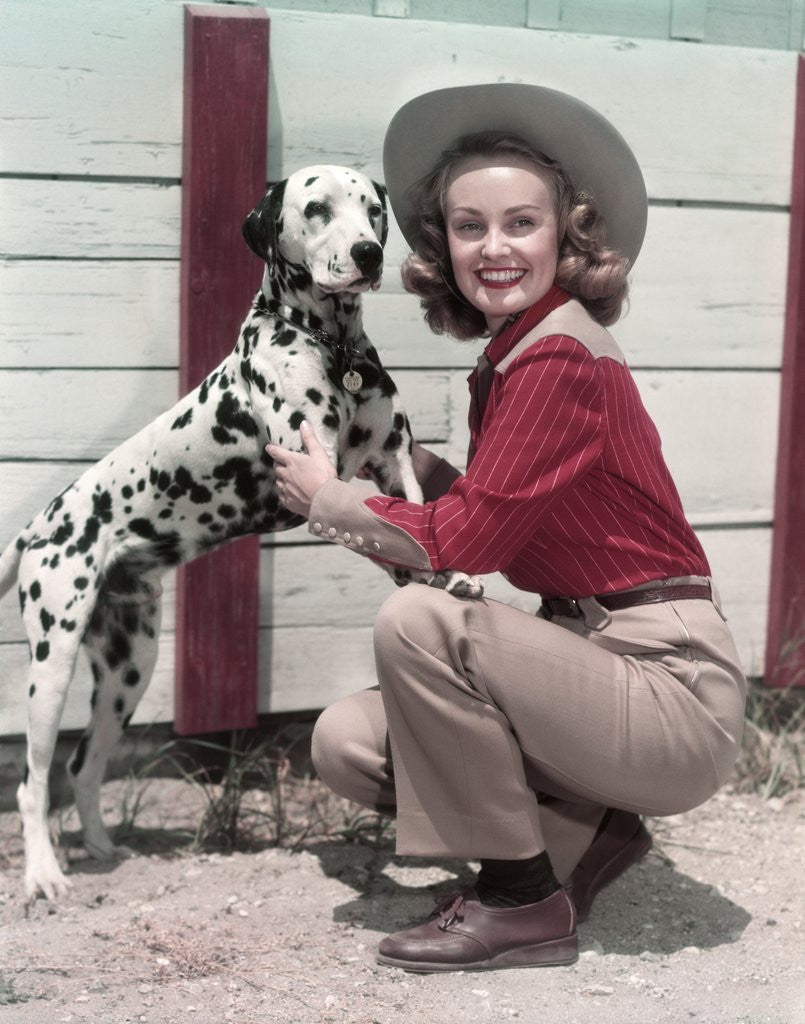 Detail of 1940s 1950s Smiling Woman Wearing Western Cowgirl Outfit Kneeling Petting Dalmatian Dog by Corbis