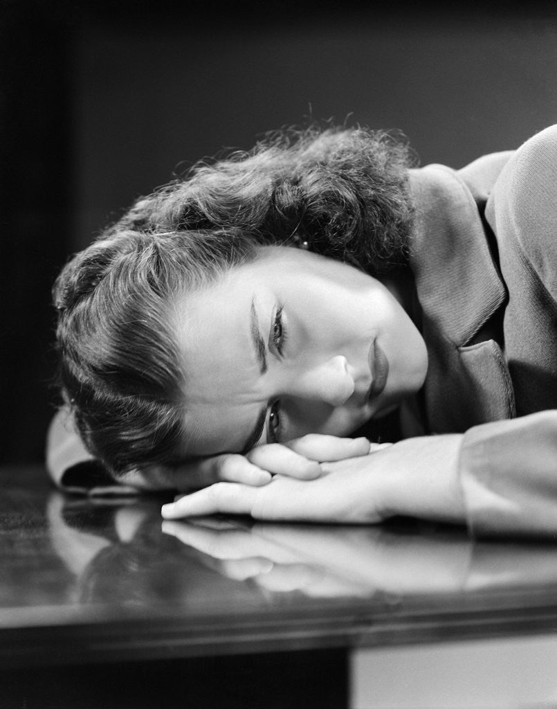 Detail of 1940s Sad Young Woman Lying Head On Her Hands On Table Desk Pain Sadness Worry by Corbis