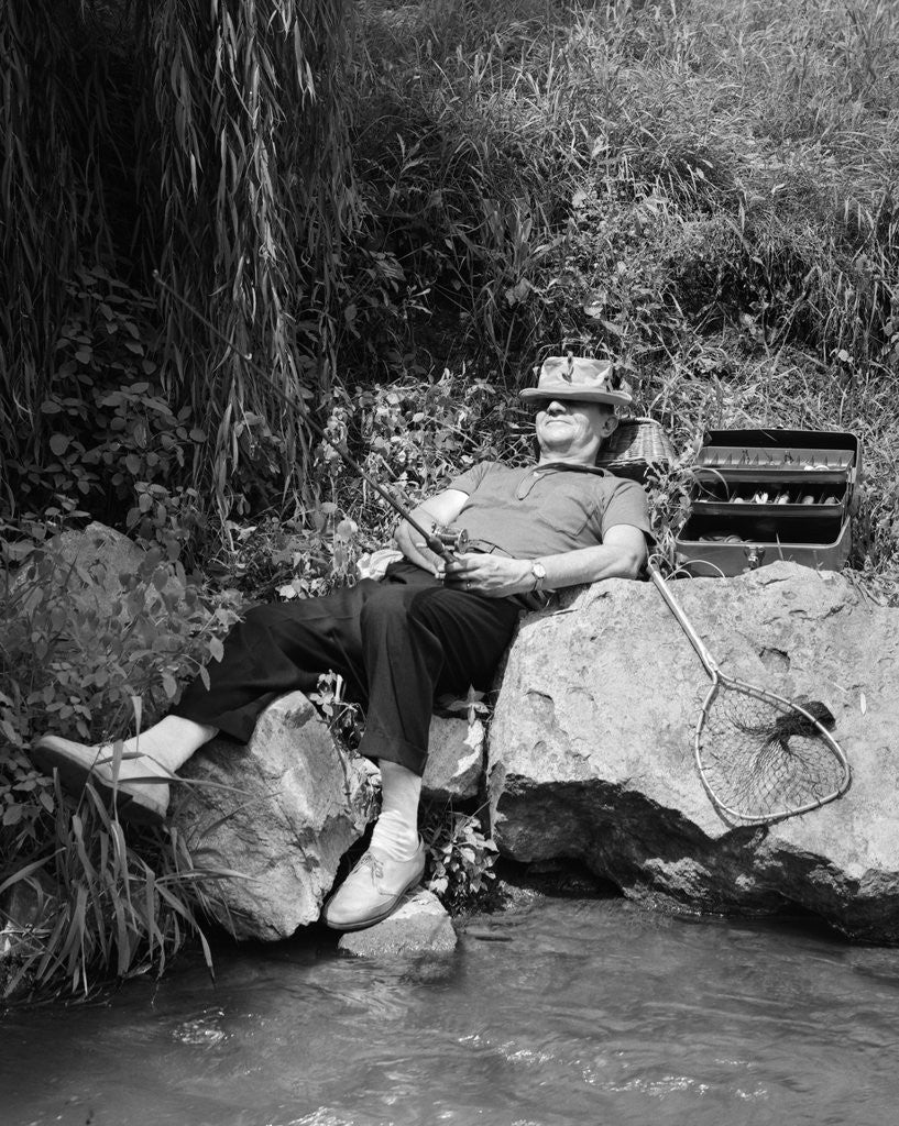 Detail of 1950s Lazy Fisherman Lying Back On Rock With Hat Pulled Over Eyes Fishing In Creek by Anonymous