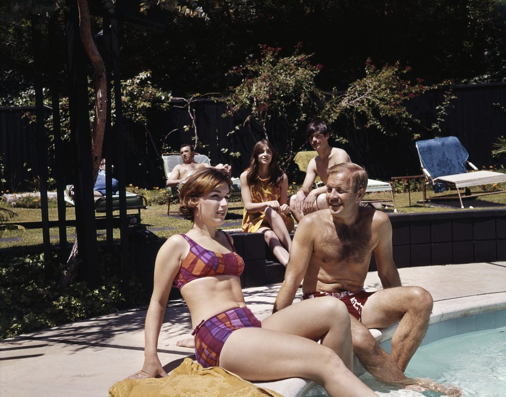 Detail of 1960s Four People On Patio Couple Man Woman Sitting On Edge Of Swimming Pool by Anonymous
