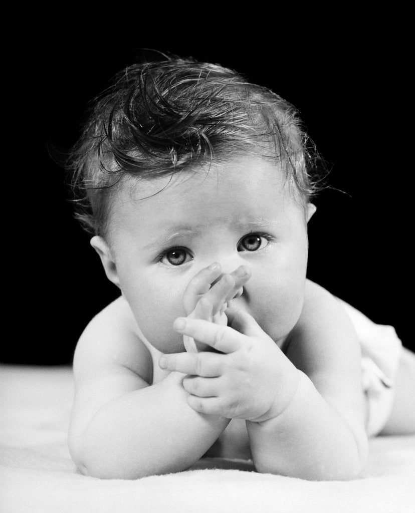 Detail of 1940s Cute Baby Sucking Thumb Looking At Camera by Anonymous