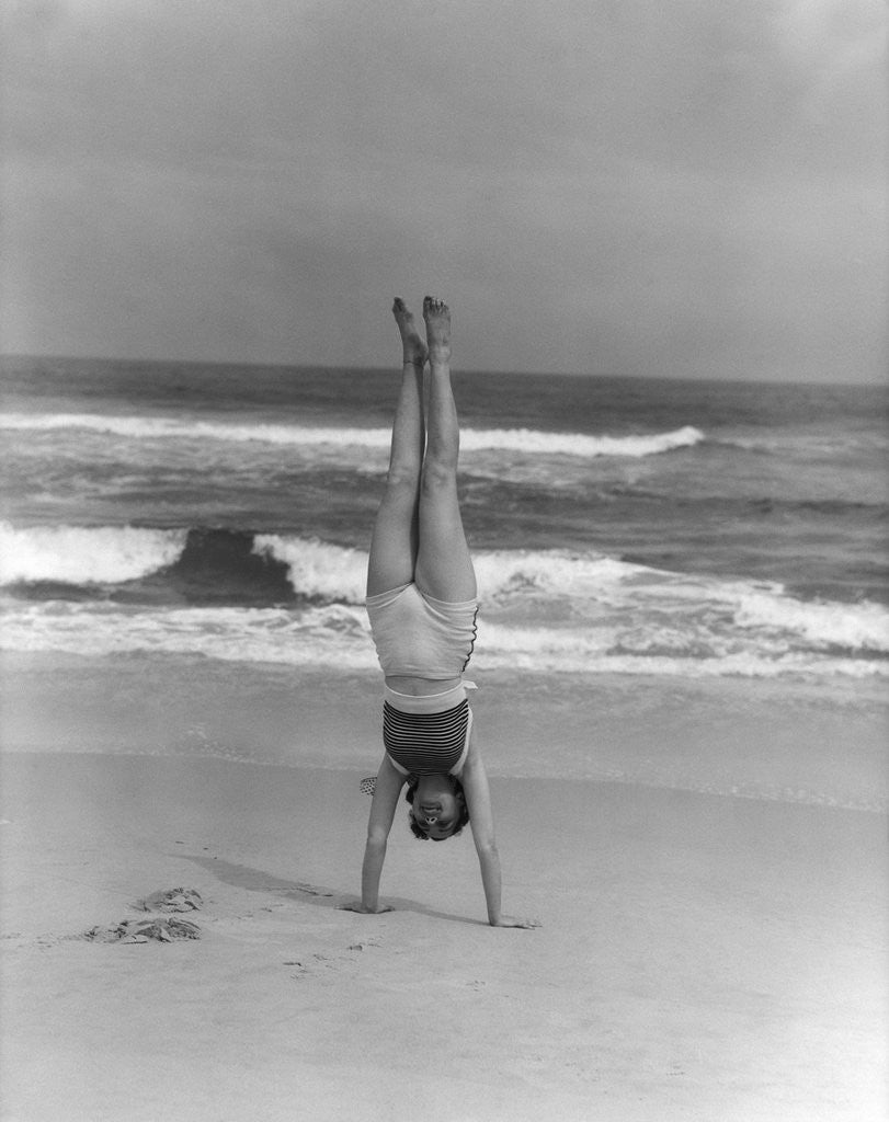 Detail of 1930s Woman Doing Handstand On Beach Upside Down Exercise by Corbis