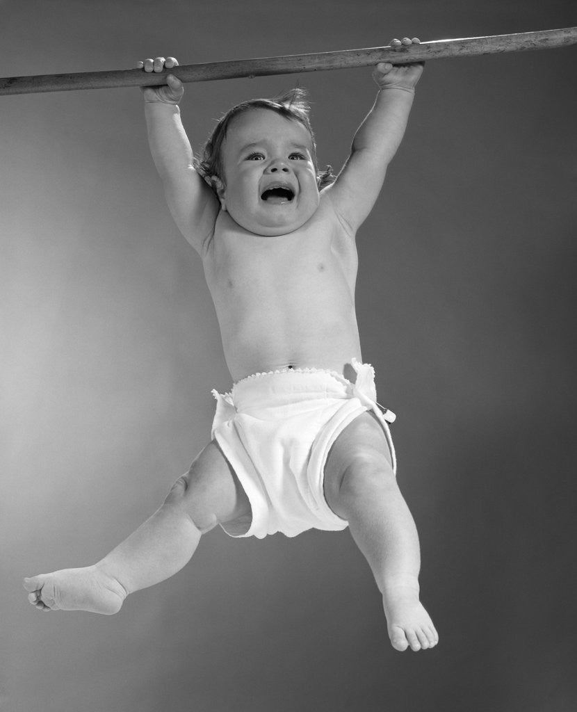 Detail of 1960s Baby Hanging From Rod With Frightened Expression On Verge Of Tears by Anonymous