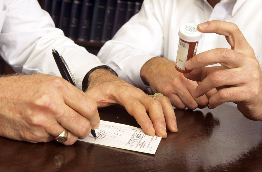 Detail of 1990s Doctor Writing Refill Prescription For Patient Holding Pill Bottle by Anonymous