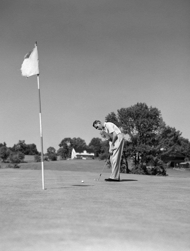Detail of 1950s Man Playing Golf Putting Golf Ball On Green To Flag And Cup Outdoor by Anonymous