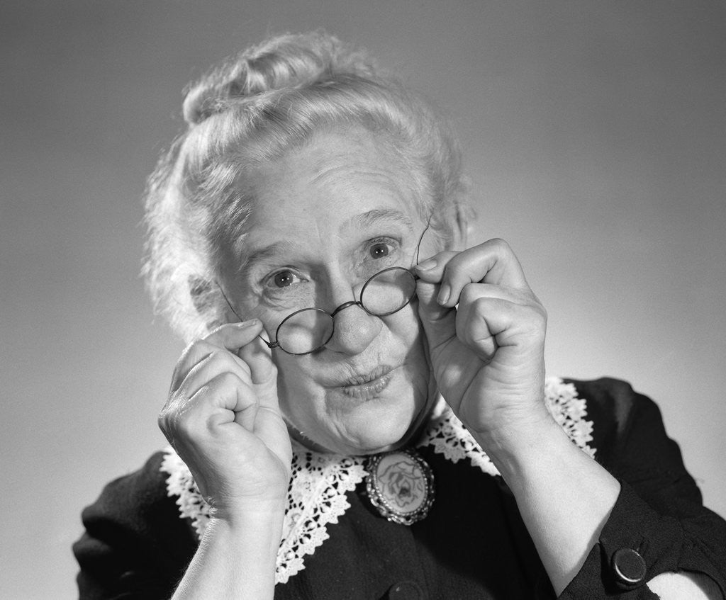 Detail of 1950s Portrait Of Smiling Old Lady Holding Her Antique Wire Frame Glasses by Corbis