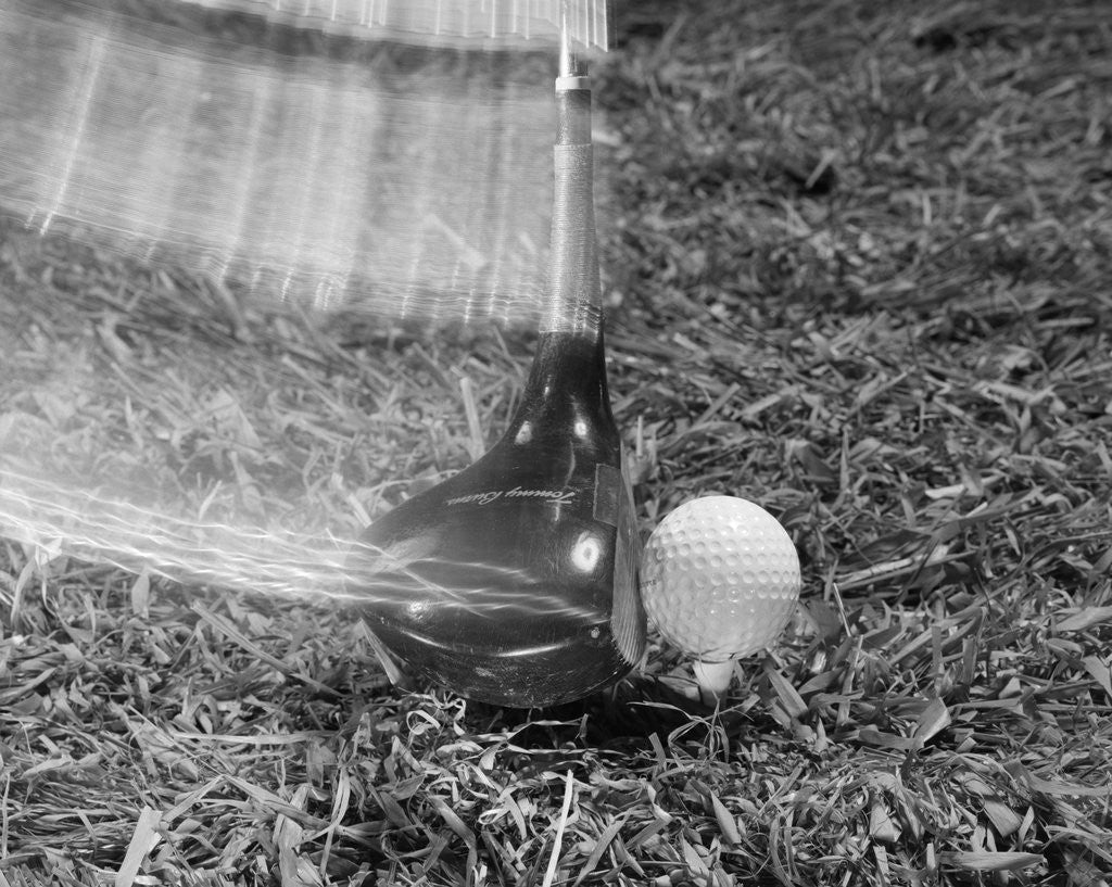 Detail of 1960s Moving Driver Golf Club Hitting Ball On Tee In Grass by Anonymous