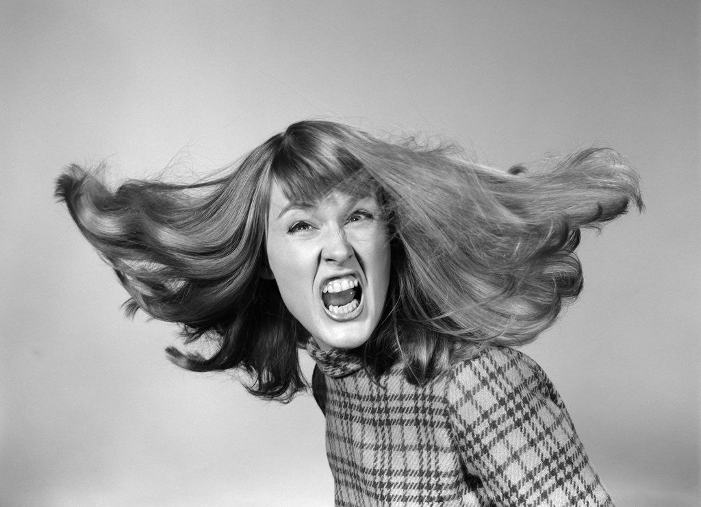 Detail of 1960s Angry Woman Yelling Gnashing Teeth Hair Flying Looking At Camera by Corbis