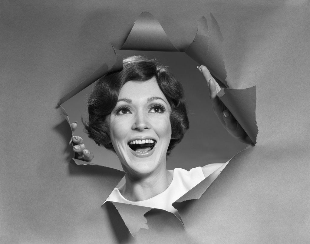 Detail of 1960s 1970s Portrait Of Smiling Woman Looking Through A Hole Torn In Paper by Anonymous