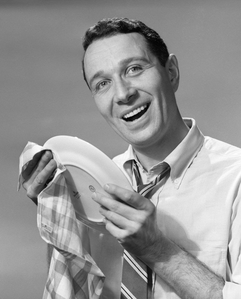 Detail of 1950s Smiling Man Drying Plate With Dish Towel Looking At Camera by Anonymous