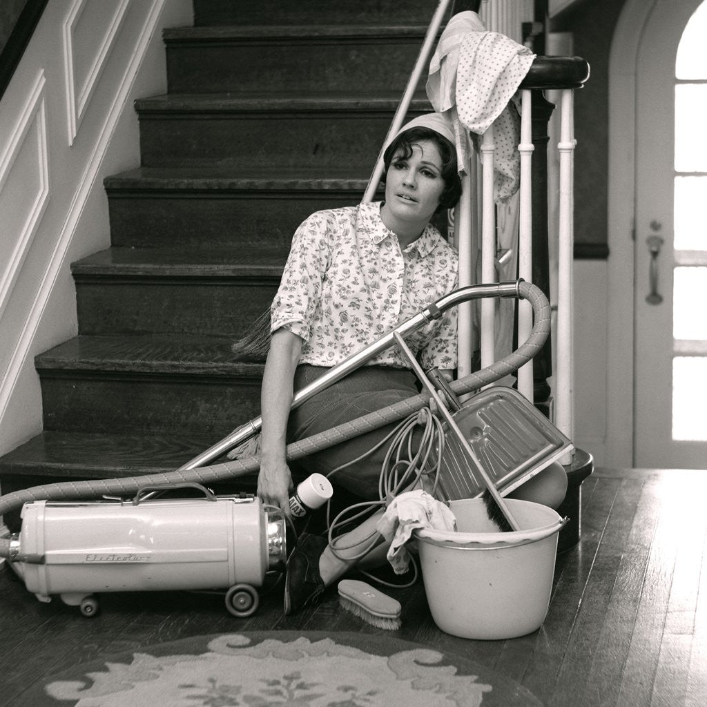 Detail of 1960s 1970s Exhausted Housewife Sitting At Bottom Of Stairs Surrounded By House Cleaning Equipment by Anonymous