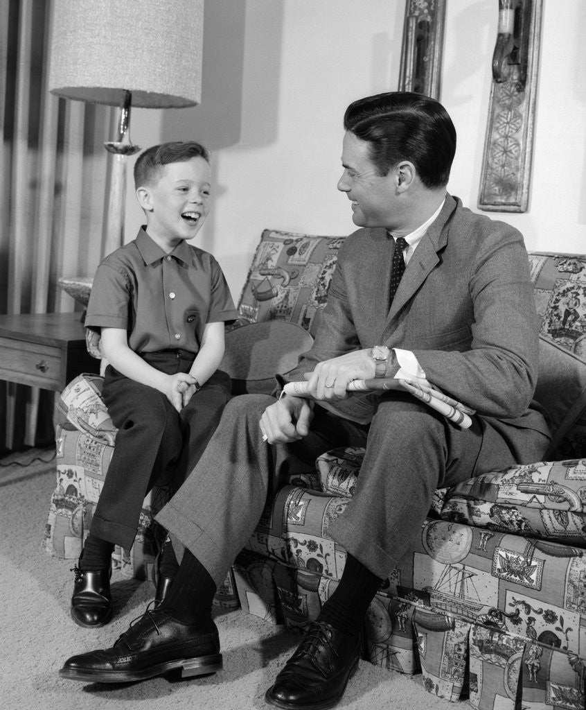Detail of 1960s Boy Sitting On Couch Smiling Laughing Talking With Dad by Anonymous