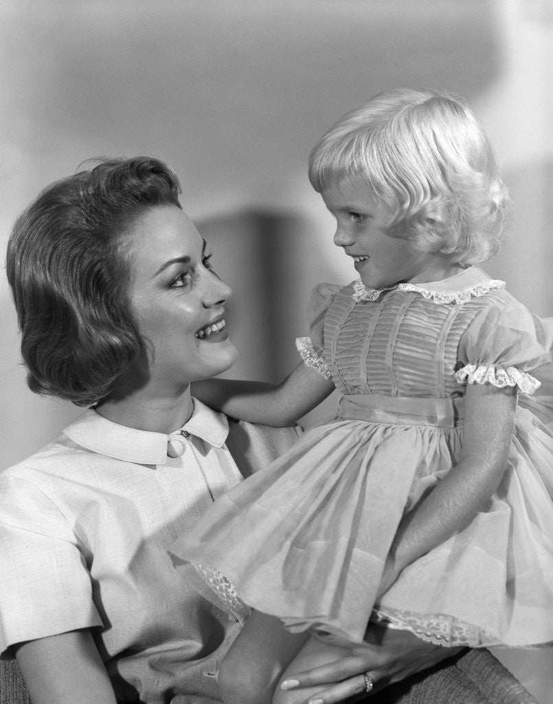 Detail of 1960s Mother Holding Little Blond Girl Wearing Fancy Dress In Her Arms Looking At Each Other by Anonymous