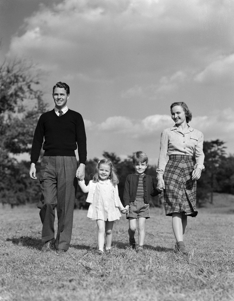 Detail of 1940s Family Father Mother Son Daughter Holding Hands Together Walking On Grass by Anonymous