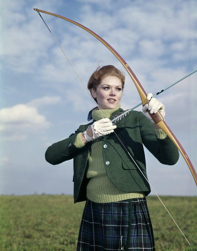 Detail of 1960s 1970s Sports Woman Archer Holding Bow Preparing To Draw Arrow by Anonymous