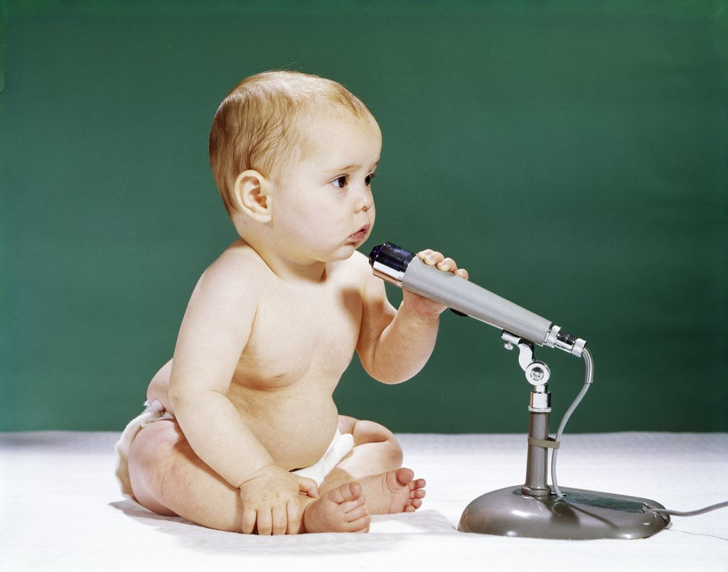 Detail of 1960s Baby Holding And Talking Into Microphone by Corbis