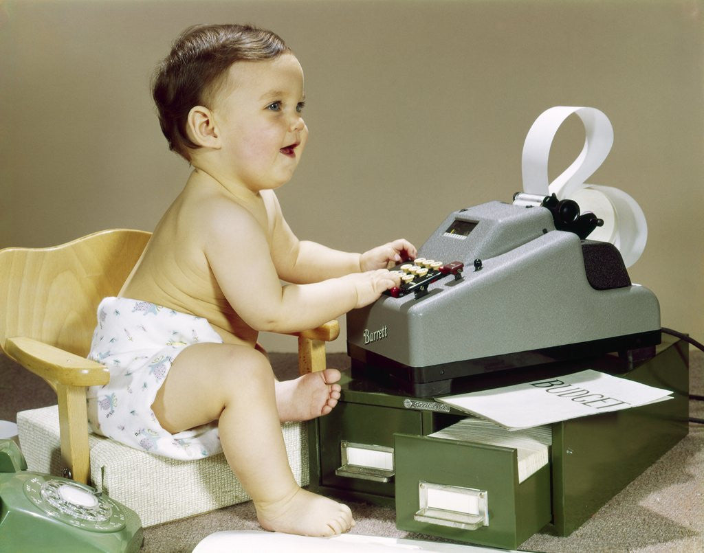 Detail of 1960s Smiling Accountant Office Worker Baby Wearing Cloth Diaper Sitting In Chair Using Adding Machine Calculator by Corbis