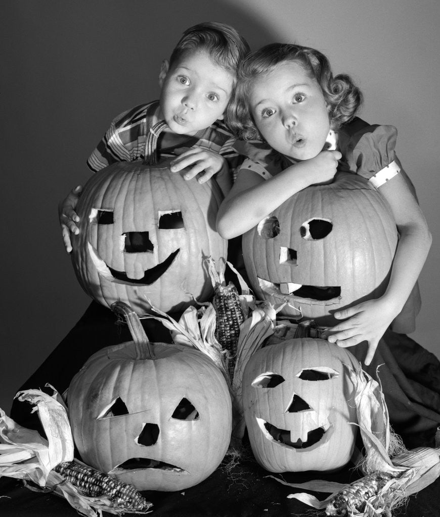 Detail of 1950s boy and girl with four jack-o-lanterns by Corbis