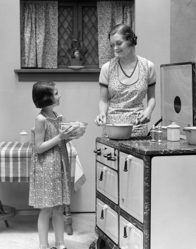 Detail of 1920s young girl helping her mother to cook by Anonymous