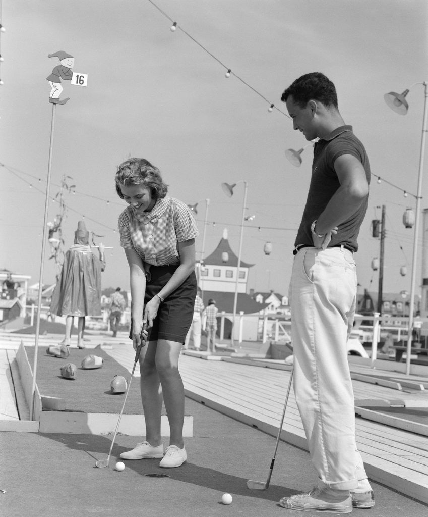 Detail of 1950s 1960s teenage couple playing miniature golf by Anonymous