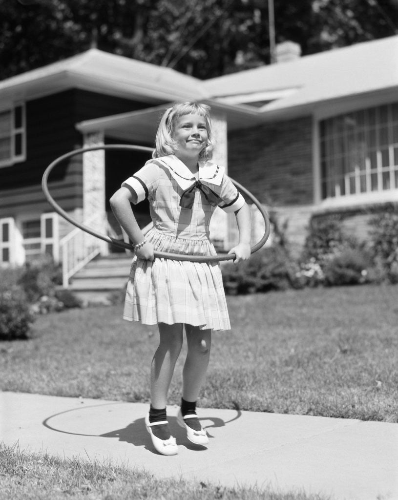 Detail of 1950s girl on suburban sidewalk playing with a hula hoop by Anonymous