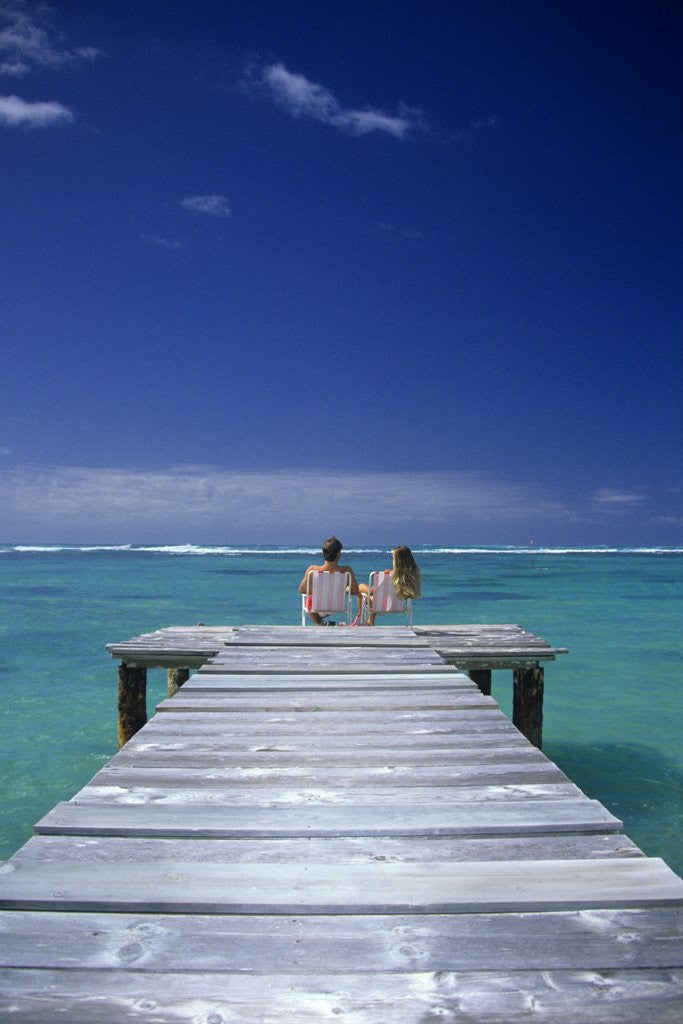 Detail of couple Sitting On A Pier In An Ocean Lagoon by Anonymous