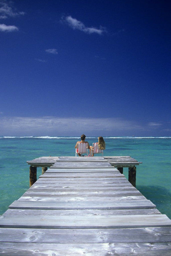 couple Sitting On A Pier In An Ocean Lagoon posters & prints by Anonymous