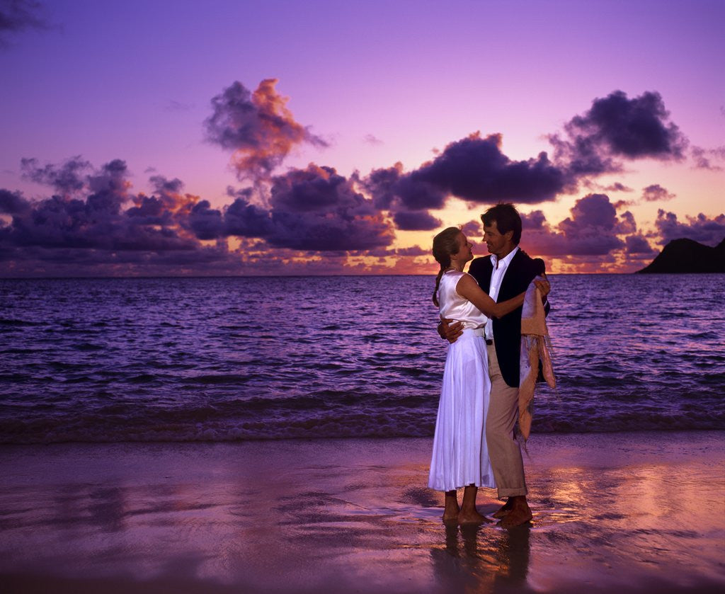 Detail of Dressed up couple embracing on the beach at sunset by Corbis