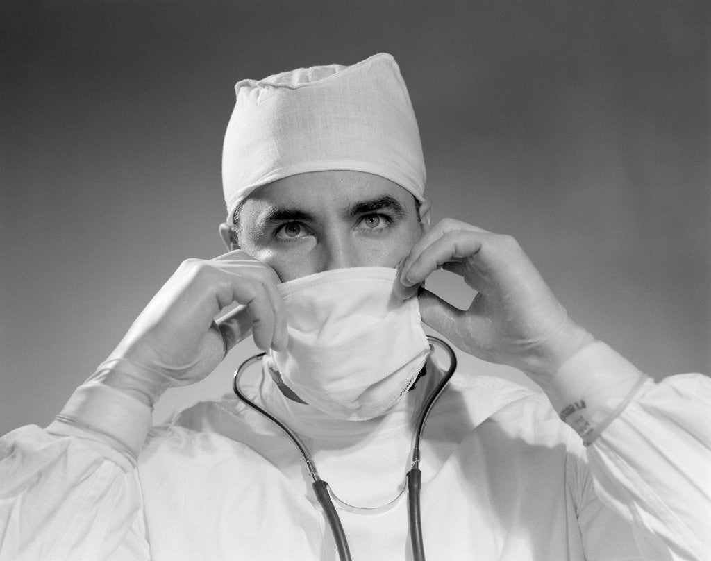 Detail of 1960s male doctor wearing surgical mask and operating room scrubs by Anonymous