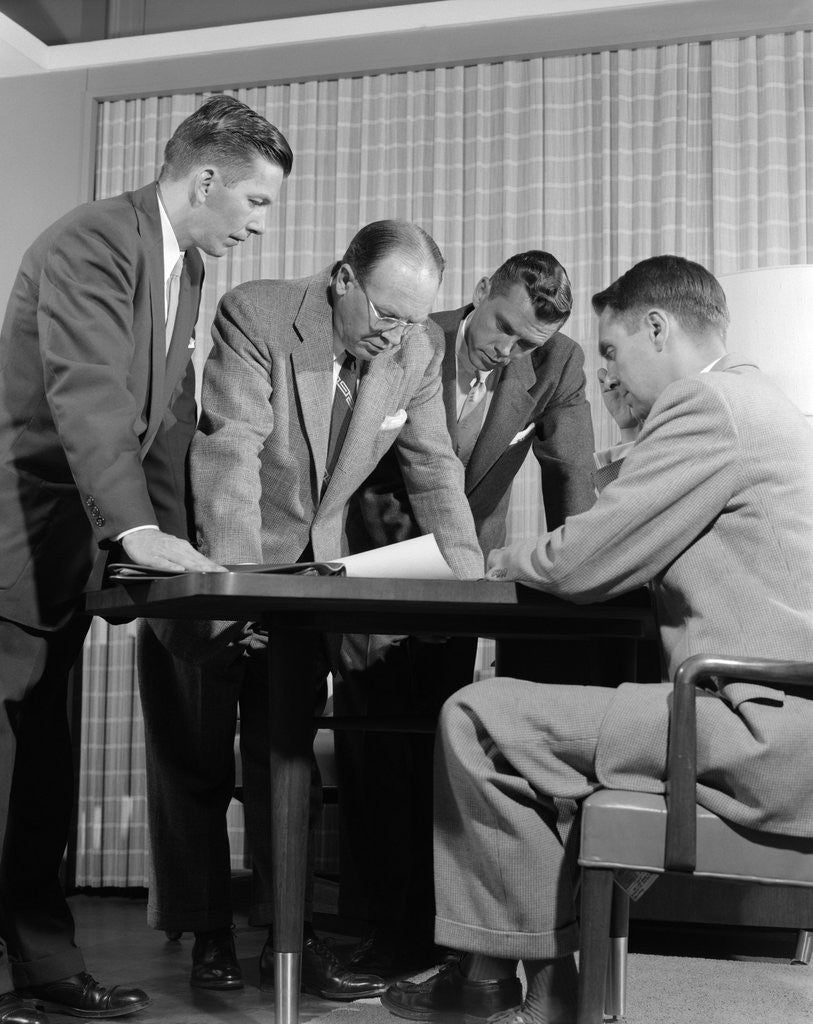 Detail of 1950s group of businessmen looking at a blueprint on a table by Anonymous
