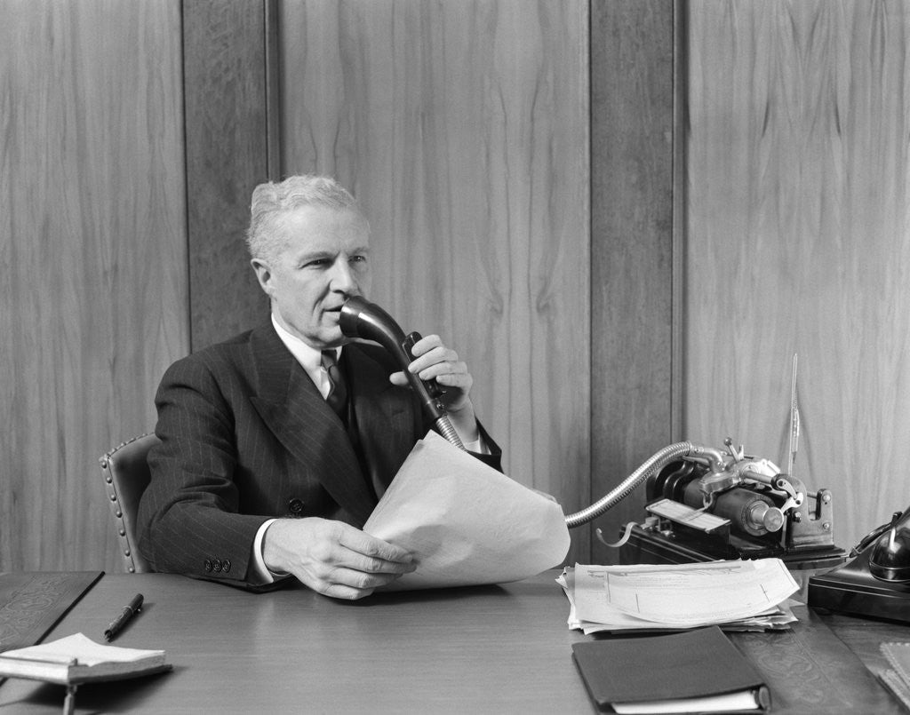 Detail of 1930s senior executive speaking into a dictaphone by Corbis