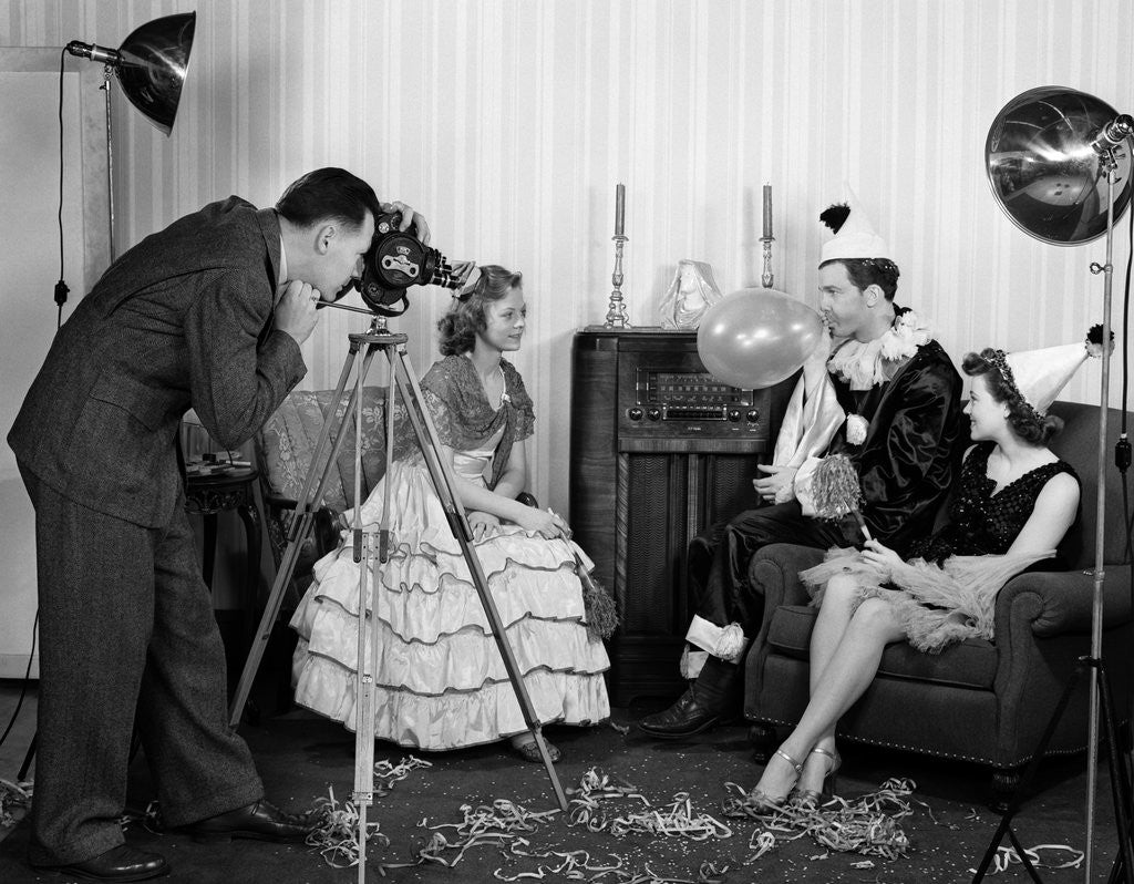 Detail of 1940s photographer taking picture of young people at New Years party by Corbis