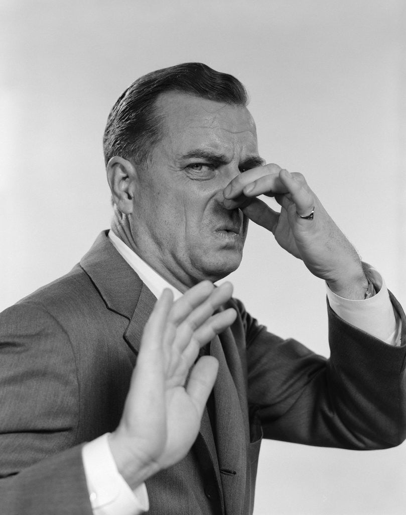 Detail of 1950s 1960s man holding his nose by Corbis