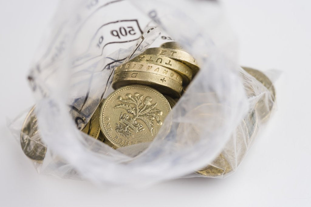 Detail of Looking down into an open money bag of pound coins by Corbis