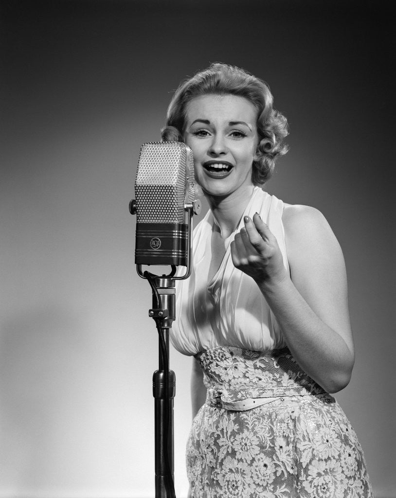 Detail of 1950s portrait of woman singing into a microphone by Anonymous