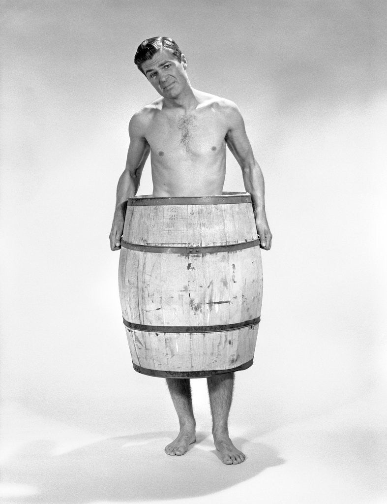 Detail of 1960s distressed naked man wearing a barrel by Corbis