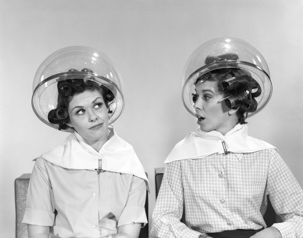 Detail of 1960s two women sitting under hairdryers gossiping by Anonymous