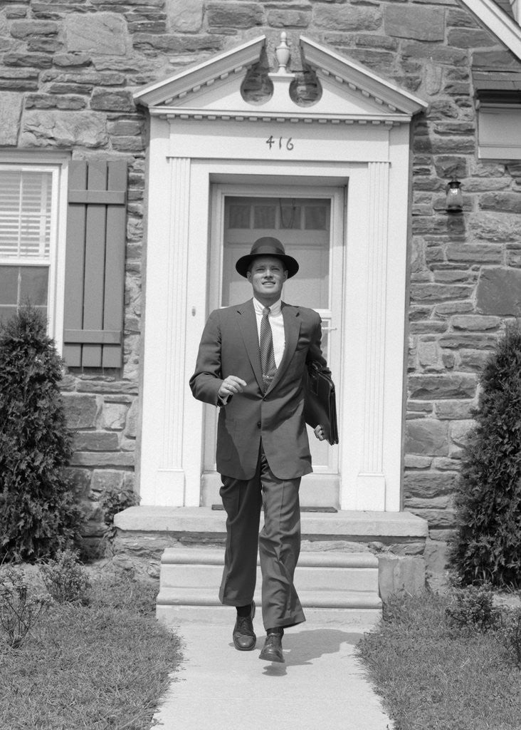 Detail of 1950s smiling businessman walking out the front door of his house by Anonymous