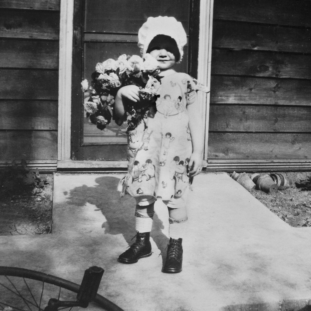 Detail of Young girl with a bouquet of flowers on her doorstep, ca. 1928. by Anonymous