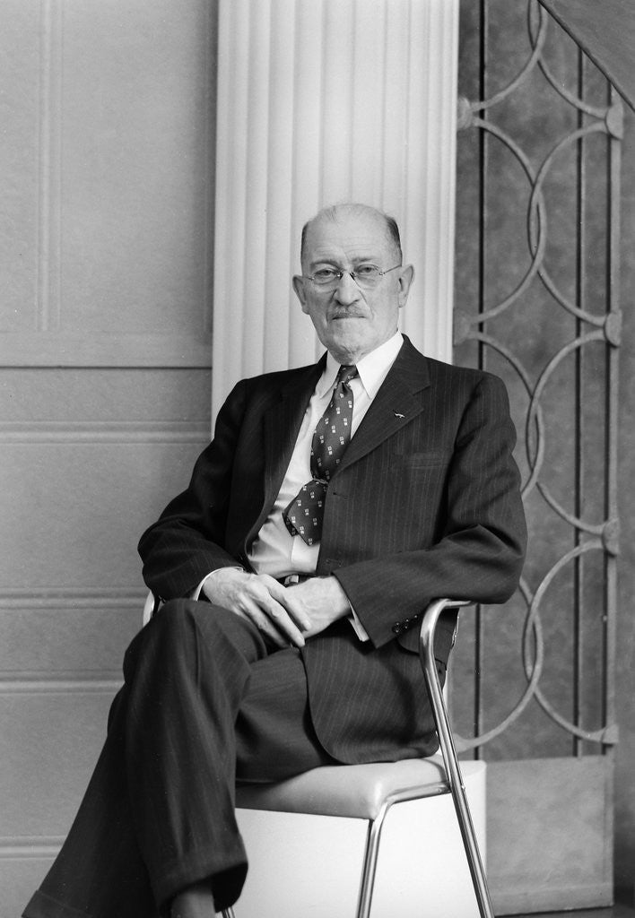 Detail of Senior man sits for a portrait in a chair, ca. 1948. by Anonymous