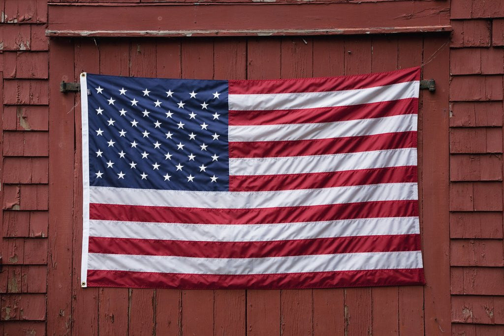 Detail of US Flag displayed on Red Barn, New England by Corbis